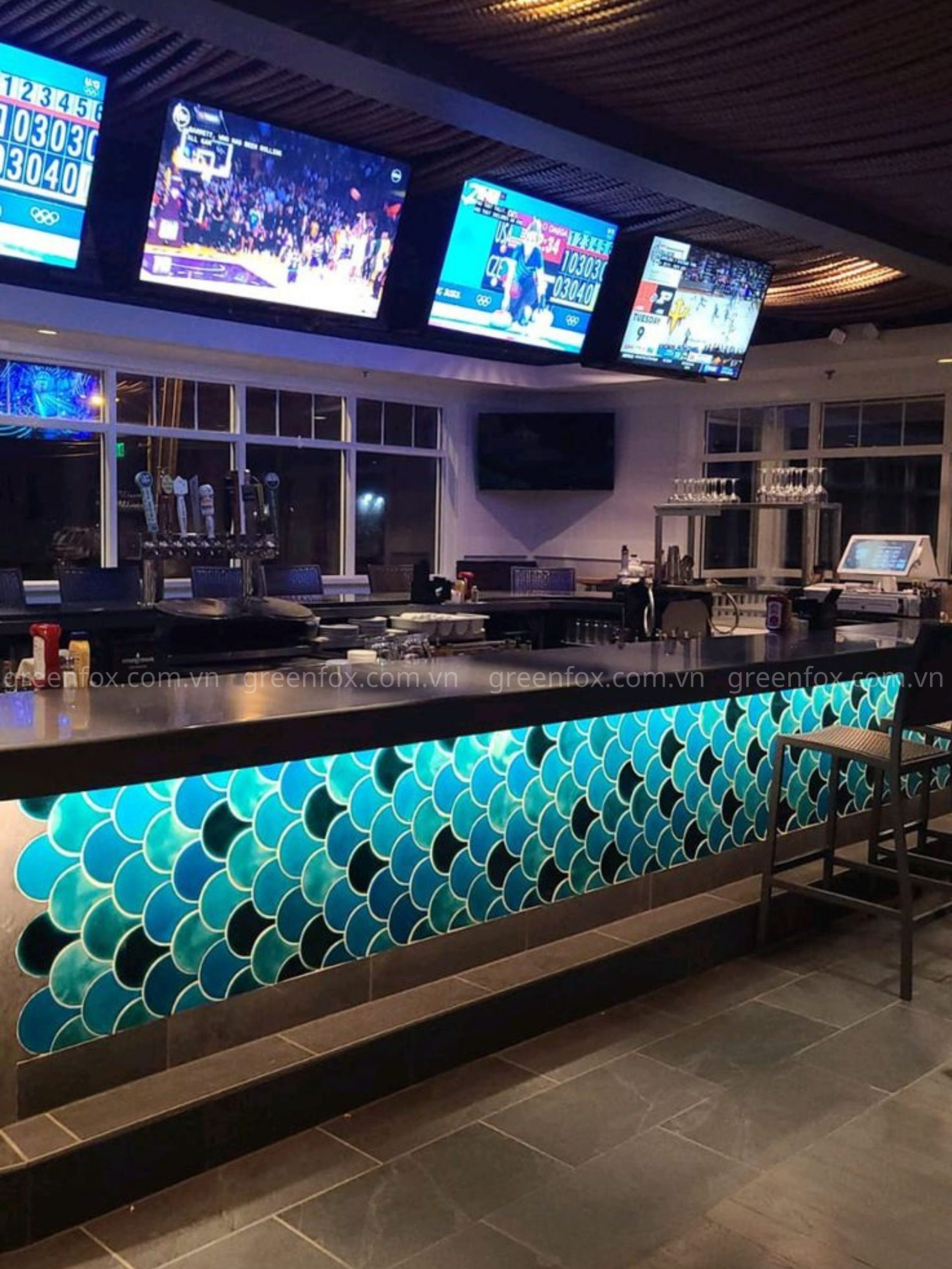 Gạch mosaic vảy cá xanh ốp quầy bar tạo hiệu ứng nổi bật và thu hút, giúp không gian trở nên sang trọng và ấn tượng hơn.