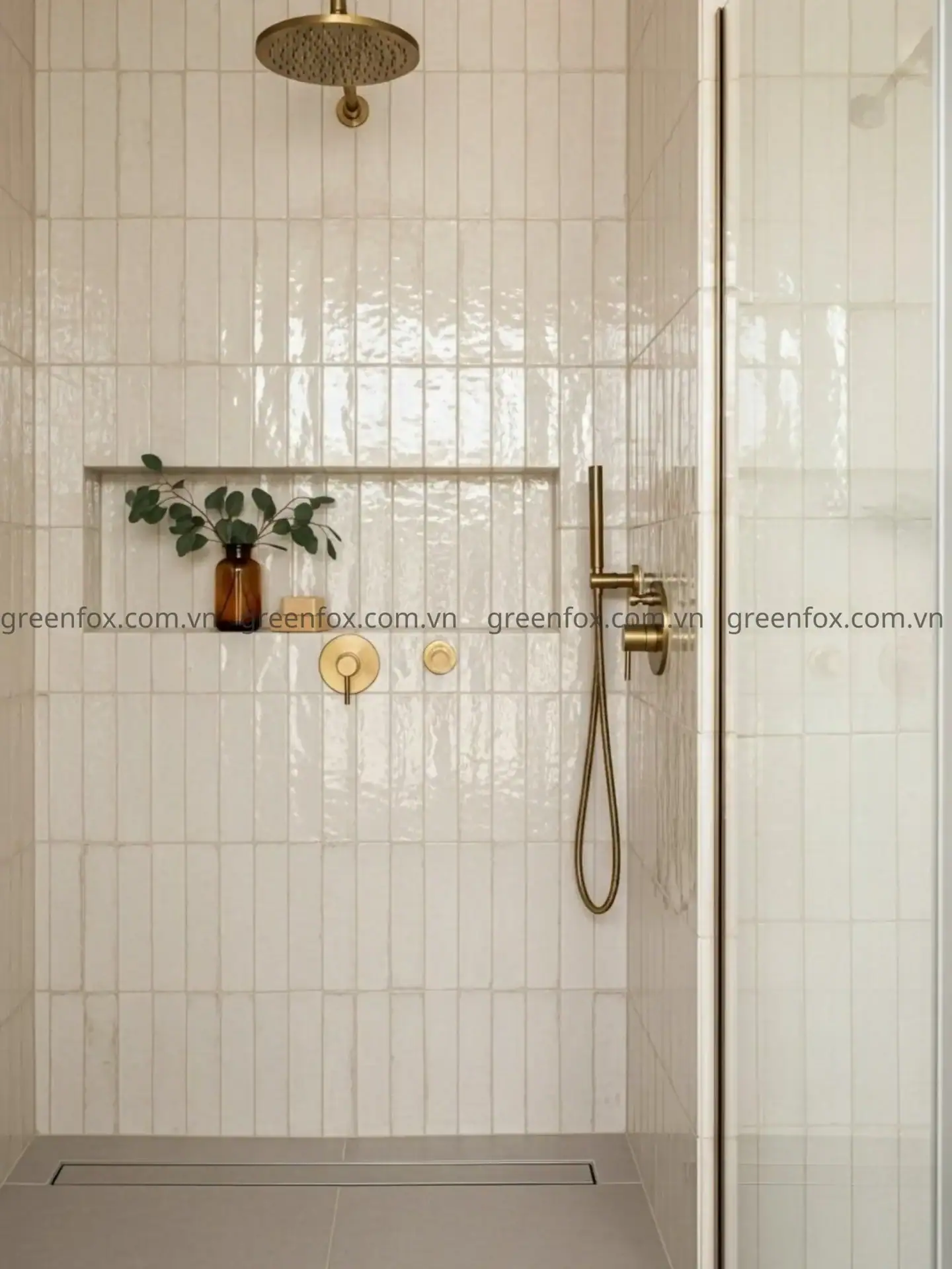 Gạch thẻ ốp tường màu kem men bóng trang trí phòng tắm hiện đại với sen tắm và phụ kiện màu đồng.