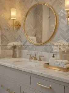 Gạch mosaic xương cá vân đá ốp tường phòng tắm với lavabo đá Marble và gương tròn.