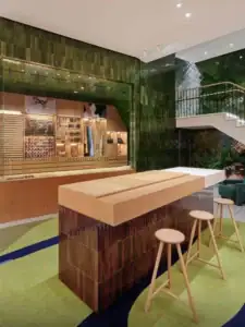 Gạch thẻ men bóng màu xanh lá ốp tường showroom kết hợp nội thất gỗ hiện đại.
