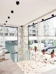Gạch terrazzo ốp tường và bệ ngồi trong không gian quán cà phê hiện đại.