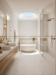 Phòng tắm nổi bật với bề mặt terrazzo trắng hạt nhỏ, lavabo đôi, bồn tắm độc lập và khu vực tắm kính theo phong cách tối giản.