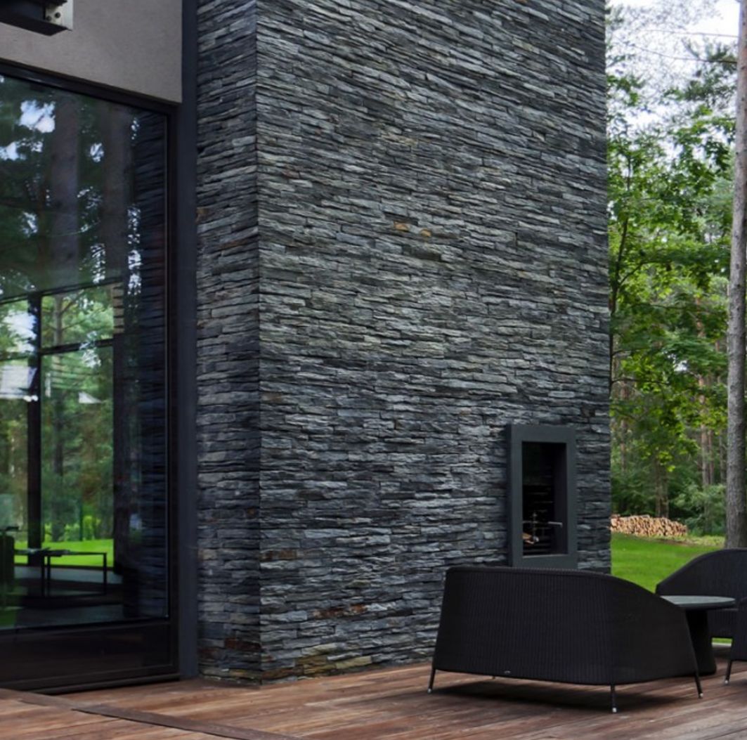 Mặt tiền sử dụng gạch giả đá slate khổ lớn, tạo hiệu ứng hình khối và chiều sâu kiến trúc sang trọng.