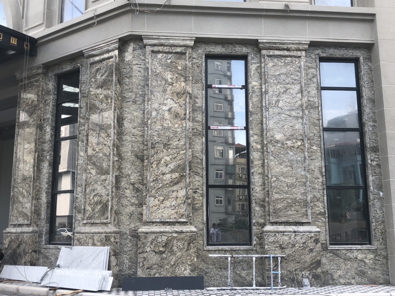 Mặt tiền sử dụng gạch giả đá hoa cương tông xám đậm, vân trắng tự nhiên, tạo cảm giác sang trọng và mạnh mẽ.