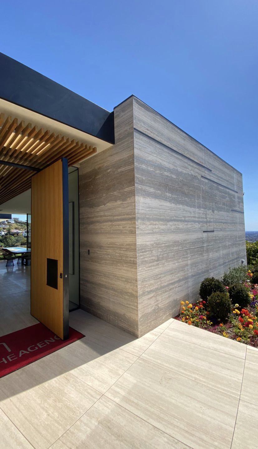 Mảng tường travertine vân ngang tông xám ghi, tạo khối kiến trúc hiện đại và liền mạch.