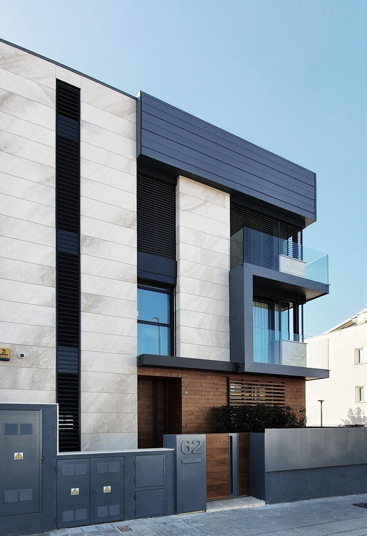 Ốp travertine khổ lớn tông kem, kết hợp khung cửa đen tạo tương phản tinh tế.