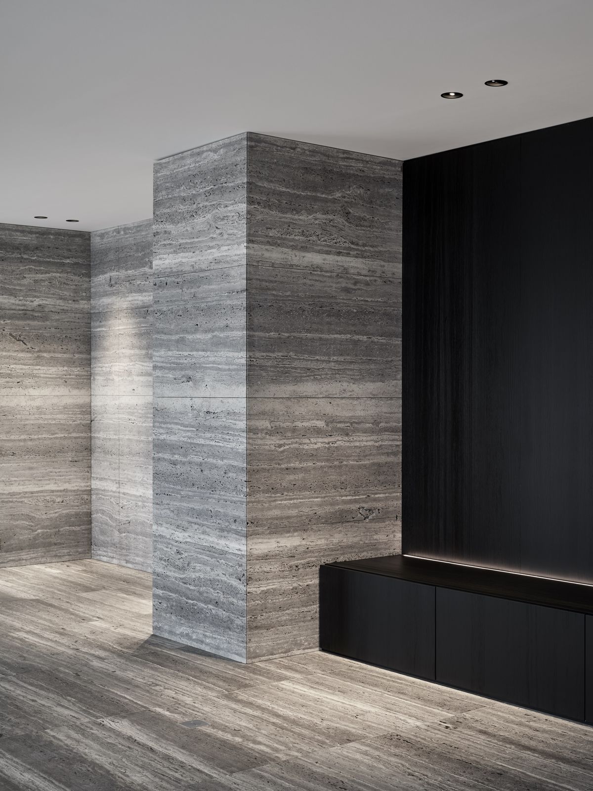 Gạch travertine màu xám vân ngang tự nhiên, ốp mảng lớn tạo cảm giác liền mạch và sang trọng. Tông xám trung tính giúp không gian hiện đại, bền màu theo thời gian.