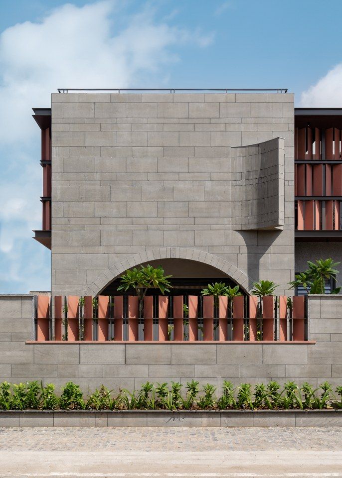 Hàng rào ốp gạch tone ghi – nền hoàn hảo cho cây xanh nổi bật.