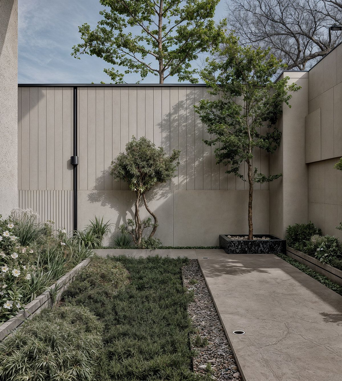 Mảng tường sân vườn ốp gạch khổ lớn màu trung tính tạo nền “êm mắt”, tôn cây xanh và lối đi.