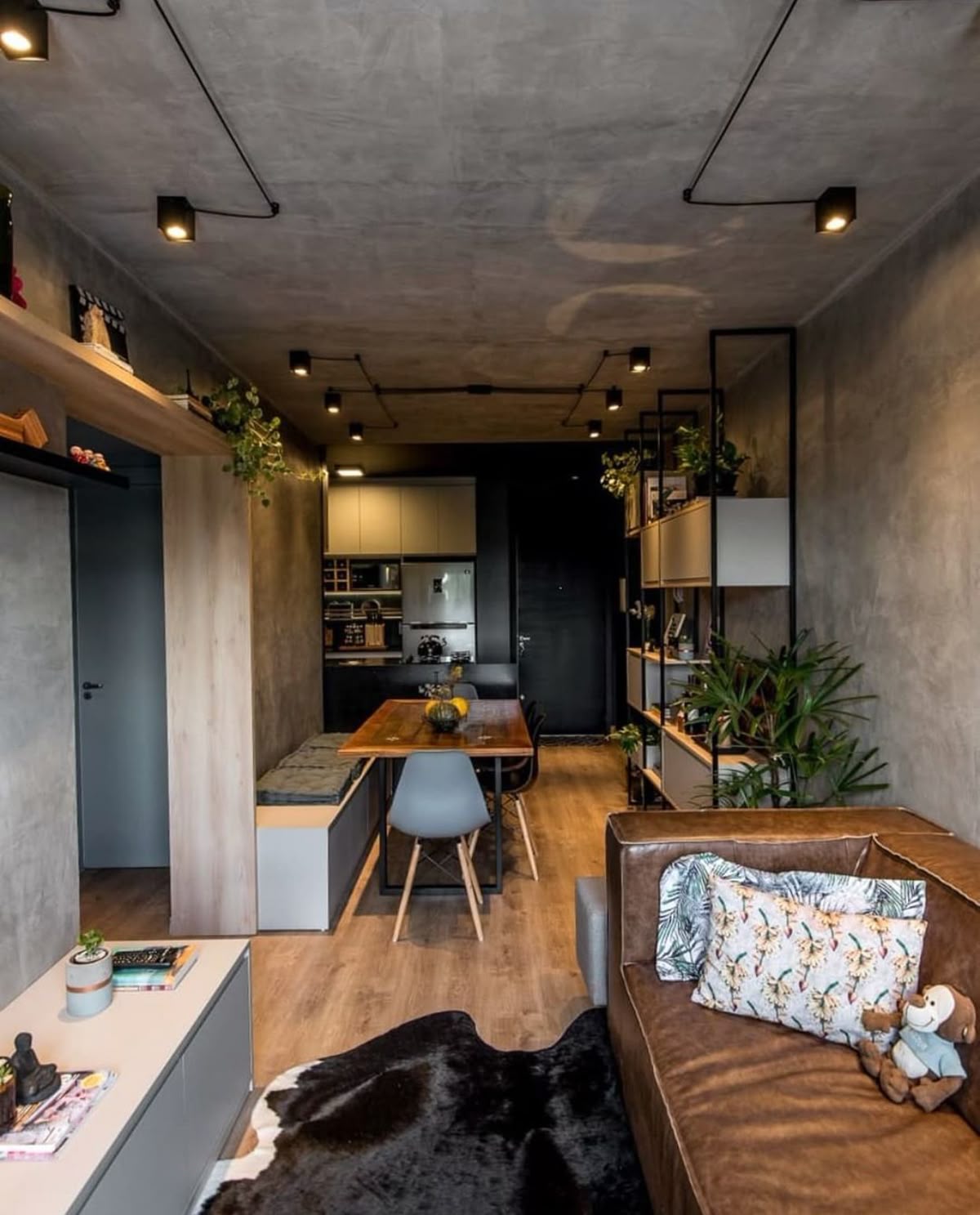 Gạch xi măng – bê tông tông xám ấm – kết hợp ánh sáng vàng giúp phòng khách ấm áp hơn, tránh cảm giác lạnh.