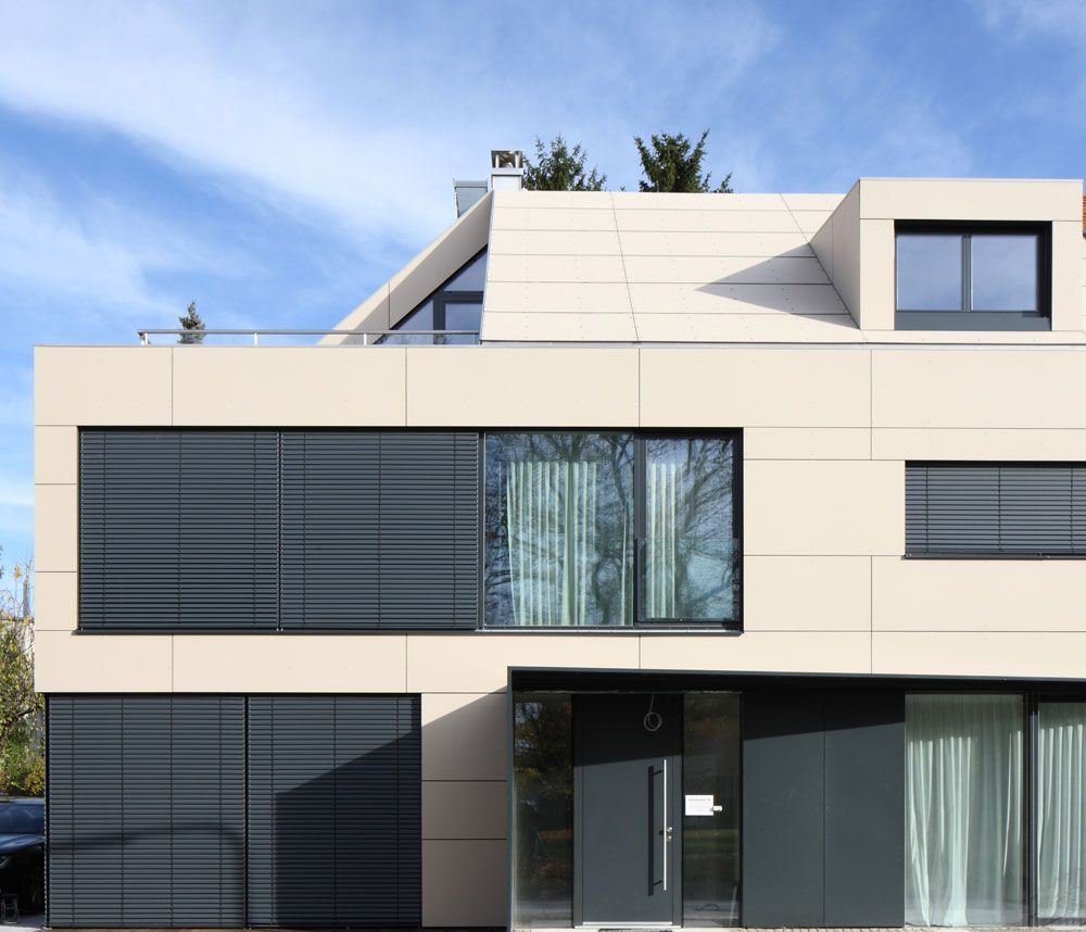 Mảng tường gạch trắng khổ lớn kết hợp cửa nhôm đen và lam che nắng tạo tổng thể hài hòa.