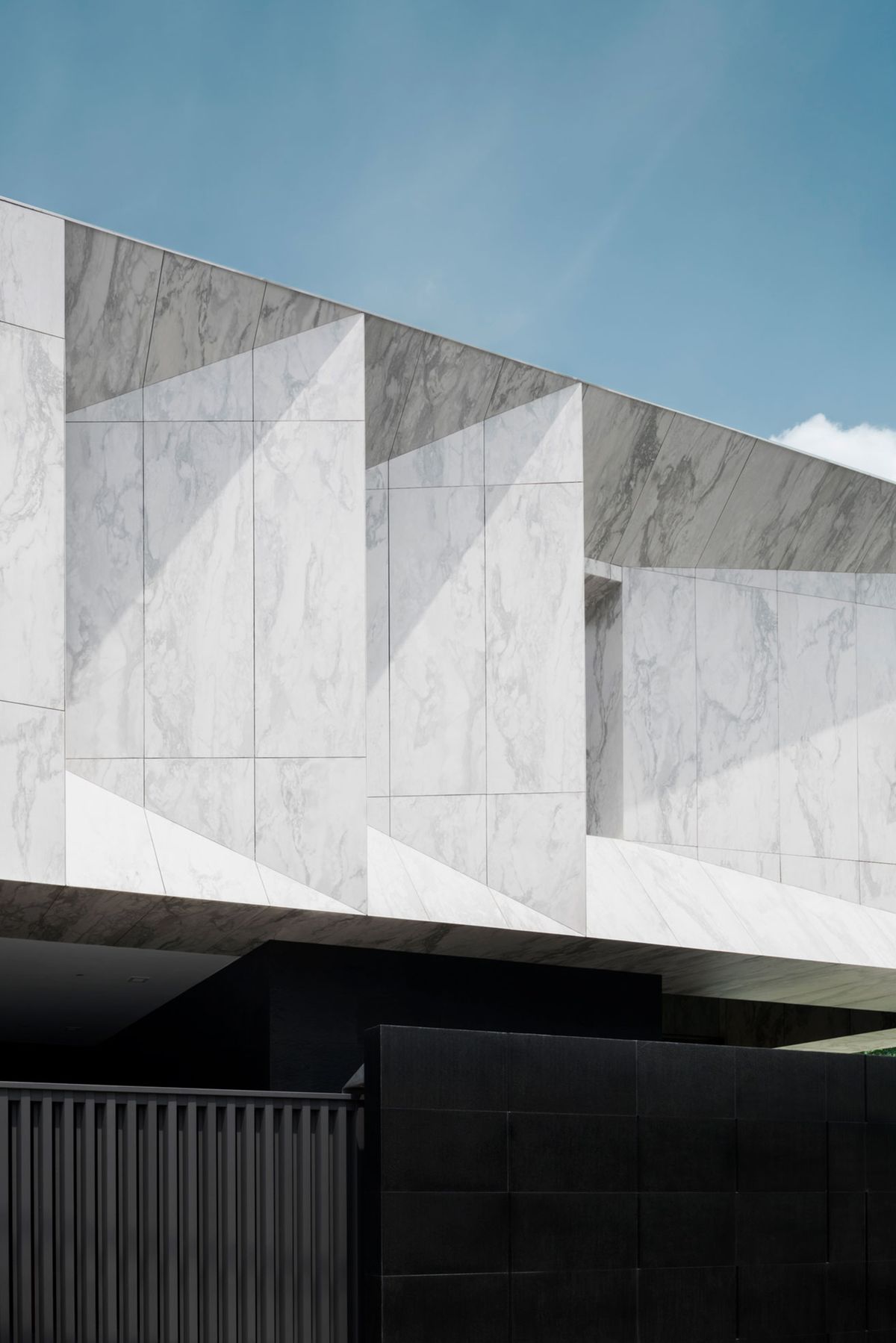 Ốp marble trắng vân tự nhiên theo mảng lớn, đường ron tối giản làm nổi bật chiều sâu và chuyển động của vân đá.