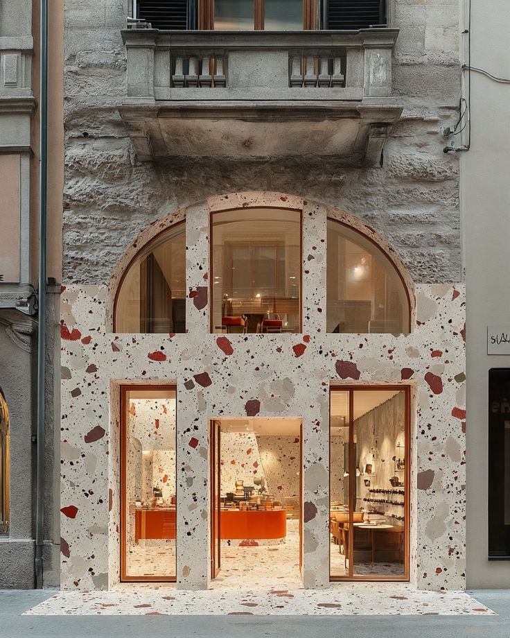 Ảnh 1:Gạch terrazzo trắng hạt lớn ốp mặt tiền cửa hàng tạo điểm nhấn nghệ thuật, nổi bật giữa kiến trúc cổ điển, mang phong cách hiện đại pha chút retro cá tính.