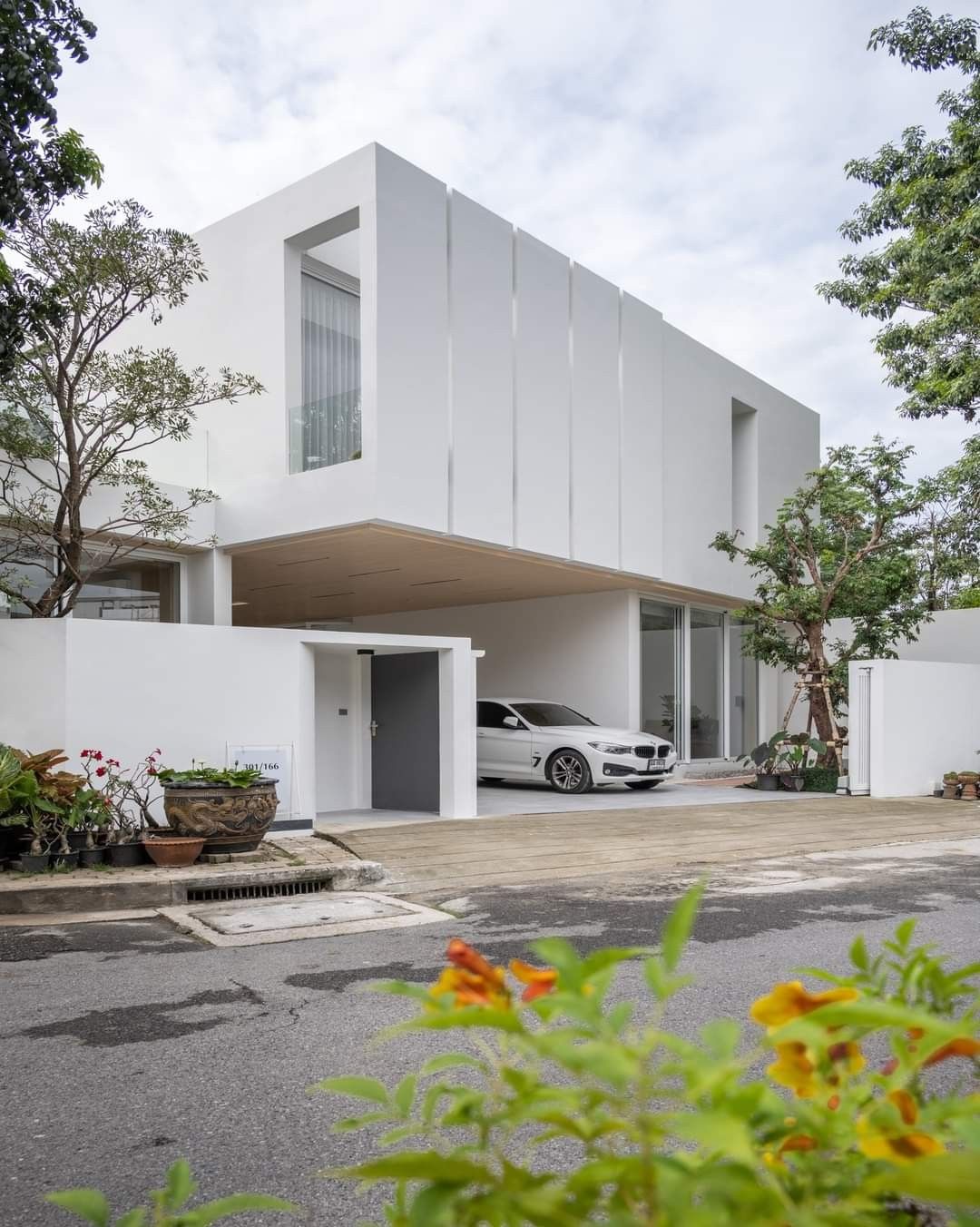 Mặt tiền trắng kết hợp mảng xanh sân vườn tạo cảm giác nhẹ nhàng, gần gũi thiên nhiên.