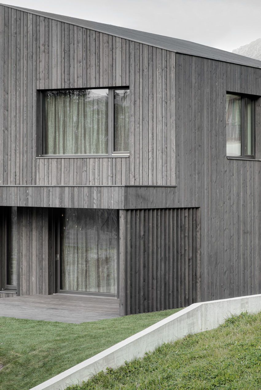 Gạch ốp màu xám vân sọc dọc tạo hiệu ứng cao ráo cho mặt tiền, phối cùng khung kính đen rất hài hòa.