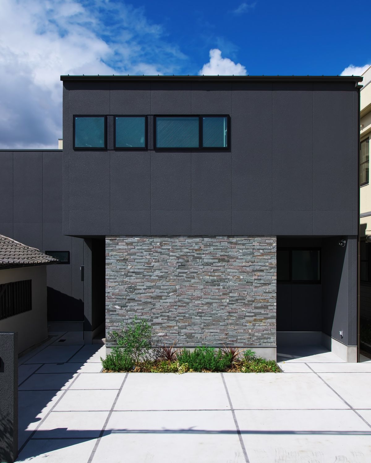 Tông xám trung tính dễ phối cùng kim loại, kính và mảng xanh, phù hợp phong cách nhà phố hiện đại.