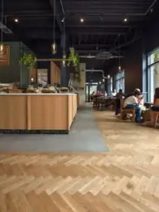 Thiết kế quán café sử dụng gạch giả gỗ lát xương cá mang đến vẻ đẹp ấm cúng và cá tính.